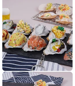 Detailed view of realistic PVC simulated oyster and scallop keychains with garlic toppings