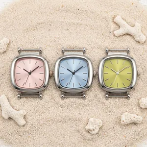 Macro detail of three colorful square women's watch heads on a sandy beach background.