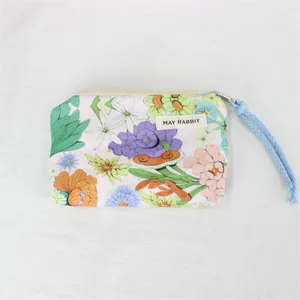 Detailed view of the cute floral print and zipper on a portable corduroy coin pouch