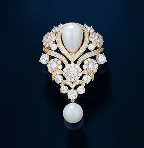 Close-up of vintage French style gold brooch with teardrop and round white pearls