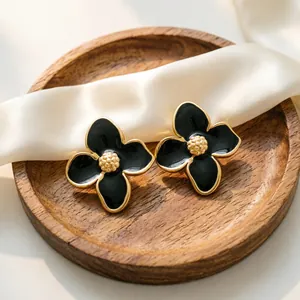 Gros plan détaillé de boucles d'oreilles fleurs vintage françaises en émail noir