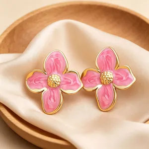 Vue détaillée de boucles d'oreilles à fleurs en émail rose avec bordure dorée