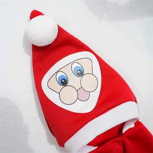 Close-up detail of a festive red pet Christmas hat featuring a cute cartoon Santa Claus face print