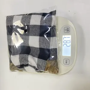 Detailed view of checkered Christmas wine sleeve showing product weight on scale
