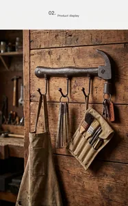 Detail view of rustic hammer shaped cast iron wall hook with hanging tools
