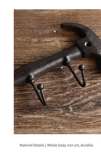 Close-up of antique cast iron hammer wall hook showing rustic metallic texture.