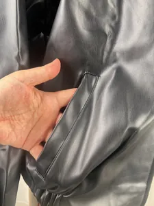 Detailed close-up view of the side pocket on a black retro motorcycle leather jacket