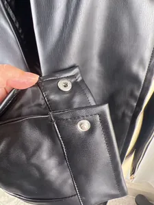 Close-up of metal snap buttons on retro black motorcycle leather jacket cuff