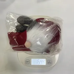 Weight measurement of a red and grey Christmas gnome faceless doll showing 154.4 grams