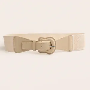 Detailed view of cream beige elastic waist belt featuring a stylish wavy buckle design