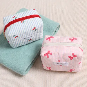 Dos lindas bolsas de maquillaje acolchadas con cerezas y lazos para organizar viajes