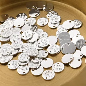 Nahaufnahme von runden Metallanhängern mit Hand-Made-Gravur für DIY-Schmuckherstellung