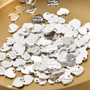 Nahaufnahme silberner Herzanhänger mit 'Handmade'-Gravur für DIY-Schmuck