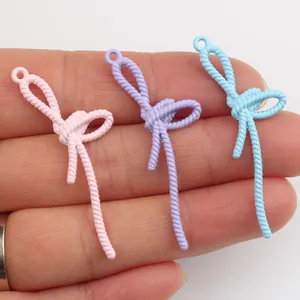 Gros plan de pendentifs nœuds en alliage pastel avec texture corde pour bijoux DIY