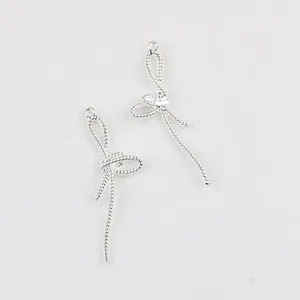 Gros plan de pendentifs nœud argentés avec texture corde torsadée pour bijoux DIY