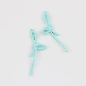 Détail de pendentifs en forme de nœud en alliage bleu clair pour la création de bijoux.