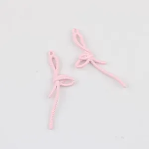 Gros plan de breloques en alliage rose en forme de nœud pour bijoux DIY
