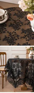 Detailed view of a vintage black lace tablecloth with elegant floral embroidery pattern