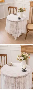 Detailed view of elegant white lace tablecloth with floral patterns in room setting