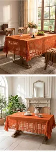 Detailed macro view of orange embossed lace tablecloth with elegant ruffled edges.