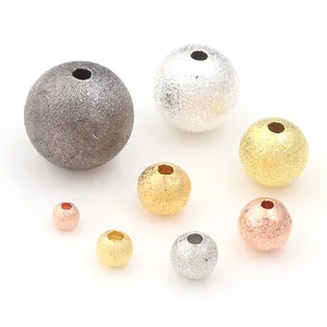 Close-up of assorted frosted copper spacer beads in various sizes and metallic finishes