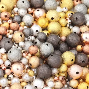 Detailed macro view of assorted frosted copper spacer beads in metallic gold and silver