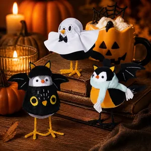 Trois figurines d'oiseaux d'Halloween sur des livres anciens avec citrouilles