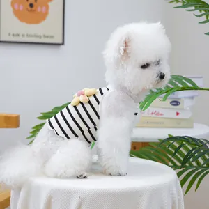 Side view detail of a striped dog vest with 3D flower decoration on a white Bichon