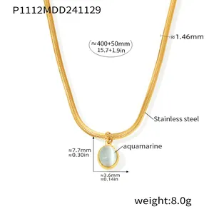 Detailed view of the aquamarine oval pendant on a gold stainless steel snake chain