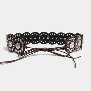 Close-up view of a vintage ethnic style wide belt with metallic grommets and tie-on cord