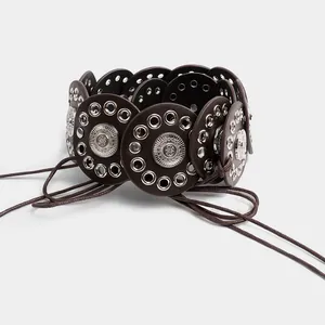 Detailed view of ethnic style wide belt with vintage metal discs and braided cords