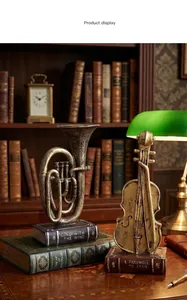 Detailed vintage bronze musical instrument sculptures of a horn and violin on a library desk
