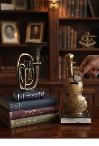 Macro view of retro violin coin bank and horn ornament on book bases in study setting.