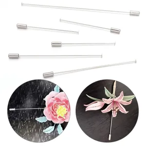 Dettaglio di lunghi spilli argentati usati come componenti per spille floreali e gioielli DIY.