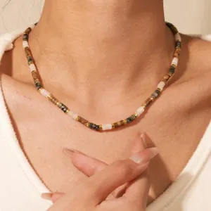 Detailed view of a Maillard-style black and brown agate beaded necklace on a model