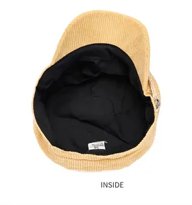 Detailed inside view of a beige corduroy navy hat showing lining and care tag