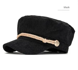 Close-up of black corduroy mariner hat with decorative rope and gold button