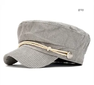 Close-up detail of gray corduroy navy cap with decorative rope and silver button