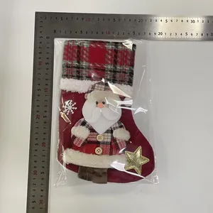 Detailed view of medium plaid Christmas stocking with Santa Claus applique and ruler measurement