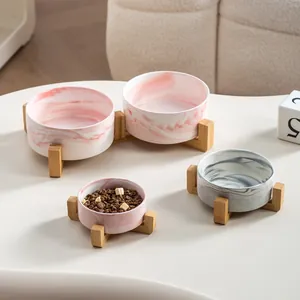 Marble pattern ceramic pet bowls with elevated wooden stands for cats or small dogs.