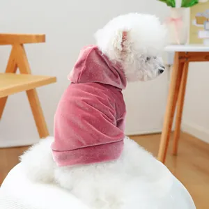 Detailed side view of a white dog wearing a premium soft pink velvet pet hoodie outfit