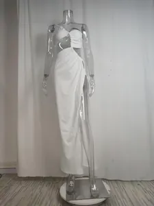 Full view of white one-shoulder cutout maxi dress with high slit on clear mannequin.