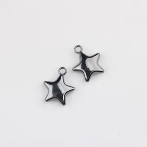Close-up detail of two dark gunmetal solid star-shaped alloy charms for DIY jewelry making