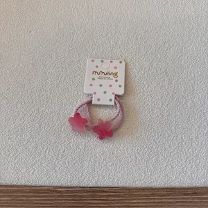 Gros plan d'élastiques à cheveux étoiles roses avec dégradé bonbon sur un support cartonné