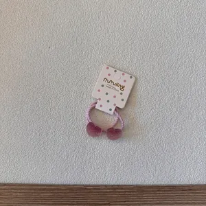 Gros plan d'un mignon élastique à cheveux cœur rose sur une carte à pois