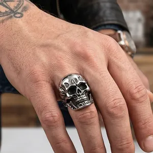 Detailed close-up of a punk style 3D skull ring on a tattooed hand with biker vibe