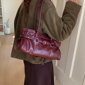 Vintage dark red faux leather underarm bag with decorative belt buckles