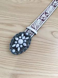 Detalle de hebilla de cinturón retro para mujer con incrustaciones de piedra blanca