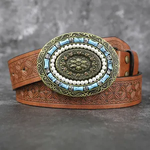 Gros plan d'une ceinture Western vintage avec boucle perle et turquoise et cuir gaufré floral.