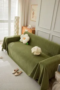 Green chenille herringbone sofa cover draped over a modern sofa in a bright living room